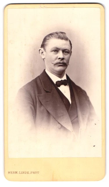 Fotografie Herm. Linde, Lübeck, Johannisstr. 31, Elegant gekleideter Her mit Zw