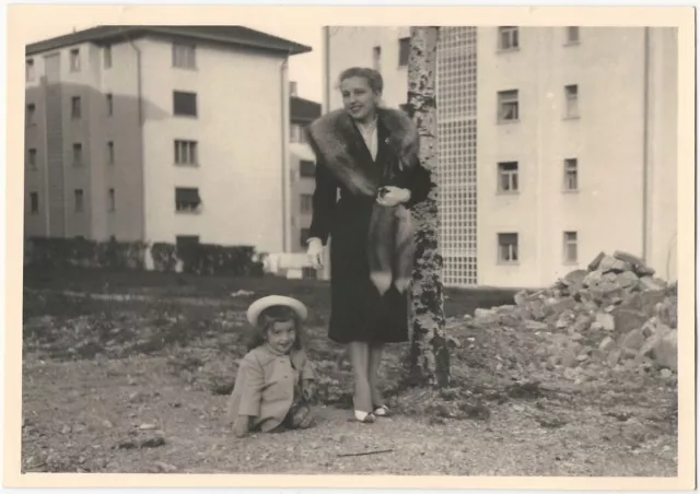 Woman in Fur Coat with Girl Modern Apartment Buildings & Rubble City Snapshot