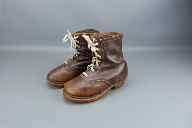 Ancienne paire de chaussure d'enfant en cuir, semelles en bois cloutées.