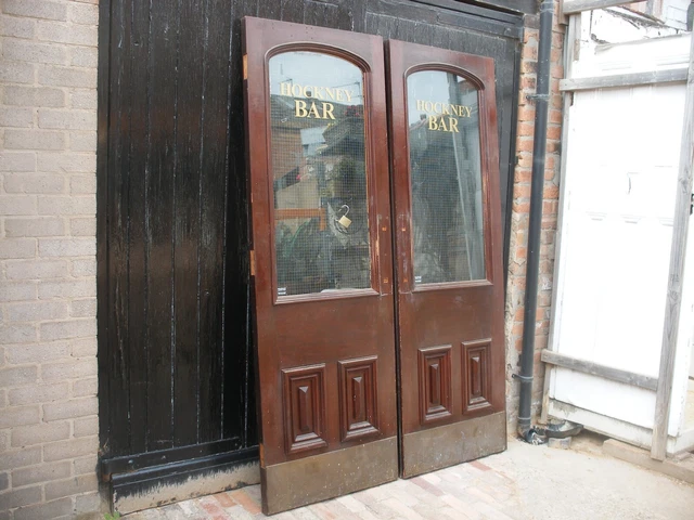Pair reclaimed solid mahogany glazed bar doors. Hockney bar.