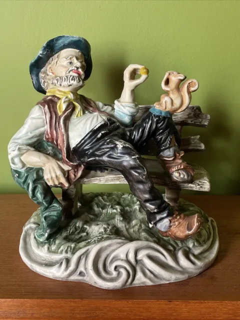 Vintage Capodimonte figurine tramp hobo man sitting on a bench feeding squirrel
