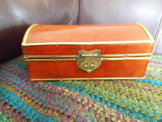 Wooden trinket box created like a treasure chest with brass inlay. Latch fitted.