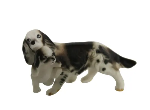 Adorable vintage ceramic spaniel dog carrying her puppy figurine
