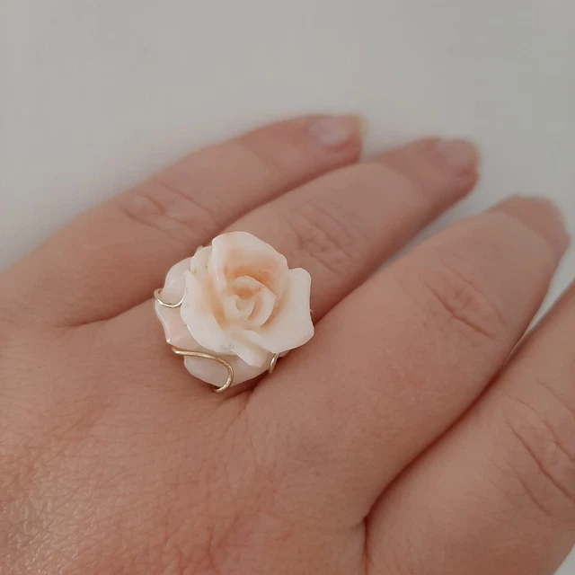 Un anello in oro con una rosa di corallo naturale.