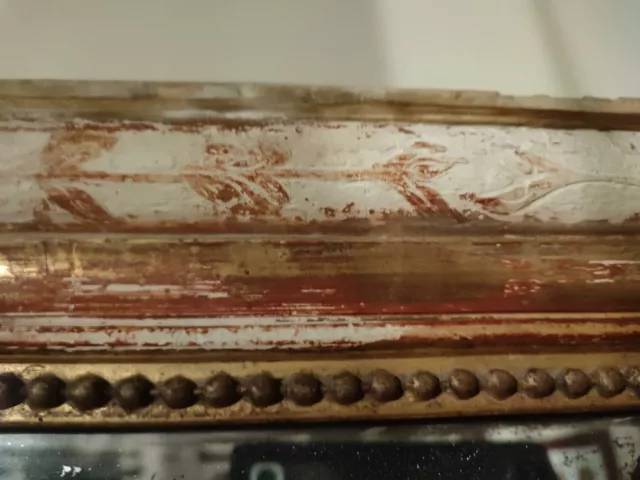 Miroir ancien en bois mouluré et doré à décor de frises de perle