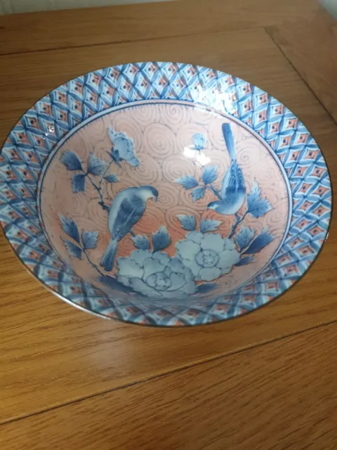 Oriental style bowl. Peach colour background with blue flowers & birds.