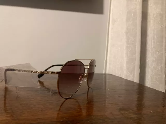 Women’s Burberry London England sunglasses gold frame with purple lenses