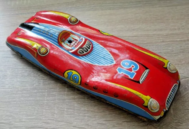 A very fancy stunt car with a pop-up man adorns this tin toy box to