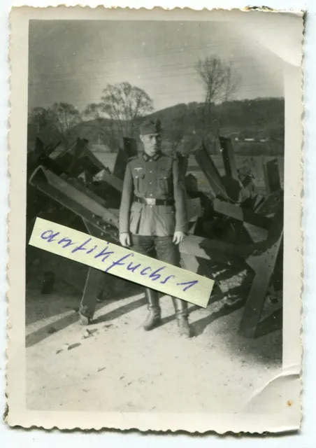 Foto : WH-Soldat vor Bunker-Panzersperren aus Stahl-Trägern im 2.WK