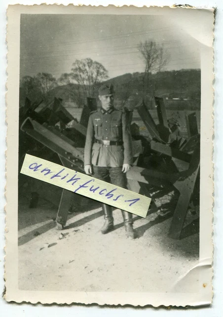 Foto : WH-Soldat vor Bunker-Panzersperren aus Stahl-Trägern im 2.WK