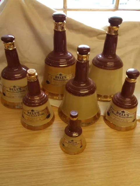 1027. 7 Assorted Wade "Bell's Whisky" Bell Shaped Bottles