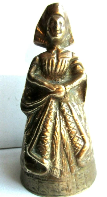 Cloche de table en bronze doré: Femme à la coiffe et au tablier brodé