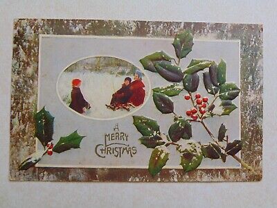 E2621 Postcard A Merry Christmas Winter scene kids playing sled holly