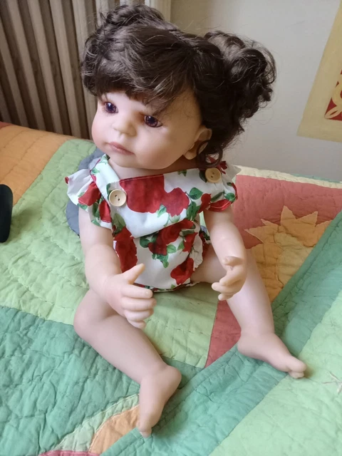 POUPEE 50 CM Elle est brune , elle porte un petit ensemble a fleurs rouge on peu