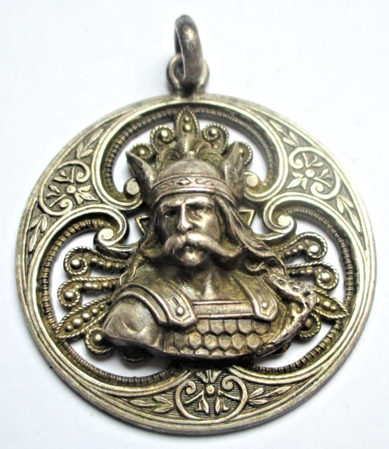 Chaine en or 750°/°°°, elle porte un pendentif reliquaire rond ciselé d'un quatrefeuille. P. 7