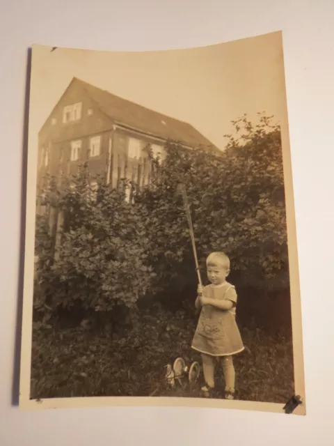 kleines Kind - Junge ? mit Spielzeug - Posthorn auf der Kleidung / Foto