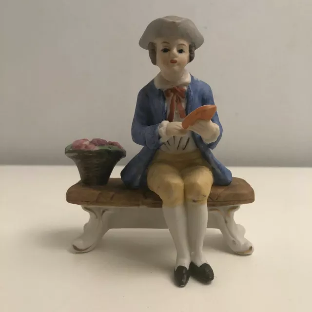Vintage Ceramic Figurine of a Colonial Man on a Bench with a Basket