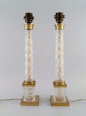 A pair of tall and sleek table lamps in clear crystal glass and brass.