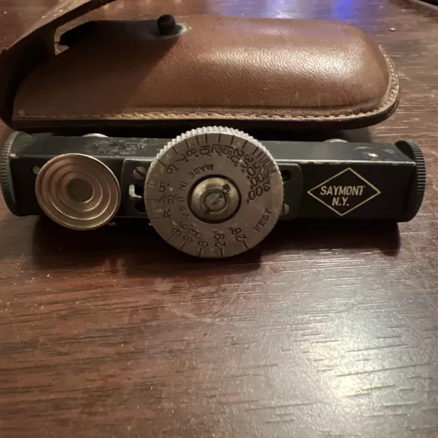 Telémetro de cámara de metal Saymont con estuche de cuero.