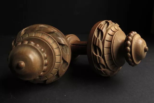 AN EARLY 20th CENTURY PAIR OF CARVED WOOD TIE BACKS/FINIALS