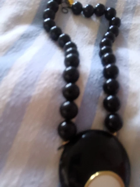 Black beaded neclkace with black pendant and white circle