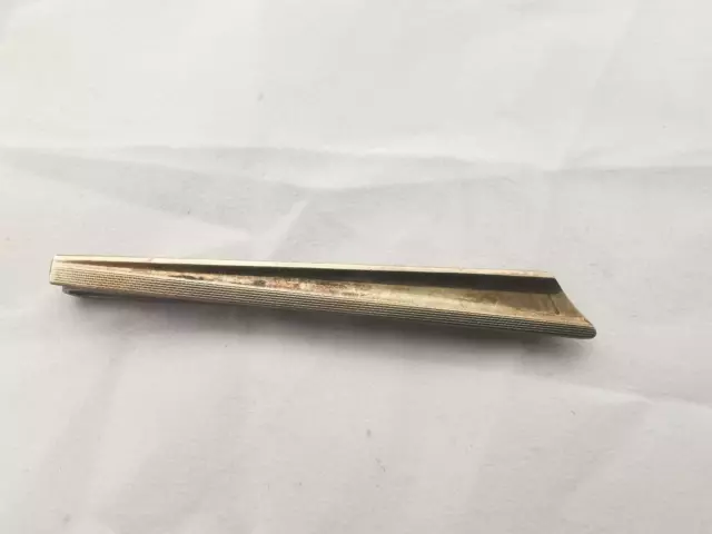 An Art Deco silver tie bar with gilded engine turned decoration