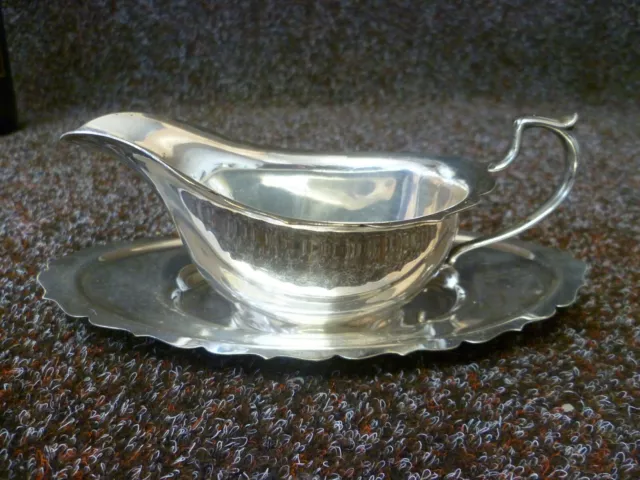 An Antique Small Silver Plated Sauce Boat & Saucer. A Silver Plated Syrup Boat