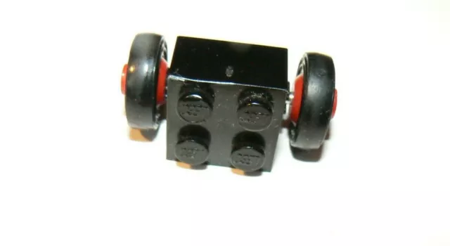 LEGO, 1 brique carrée de 4, noire, avec essieu de 2 roues aux jantes rouges, TB
