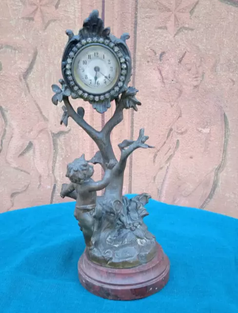 Grazioso orologio scultura in bronzo con angioletto,  base in marmo