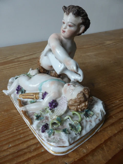 Groupe en biscuit polychrome/Représentant un Faune abreuvant Cupidon