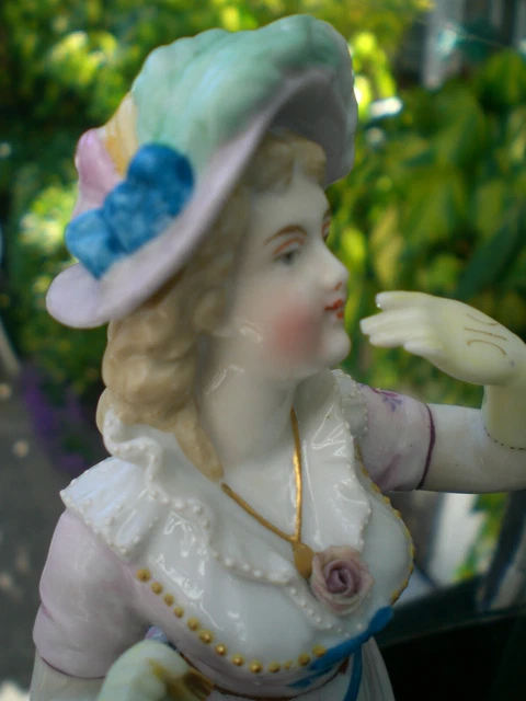 Sujet Porcelaine biscuit polychrome au naturel signé. Jeune femme à l'aumônière