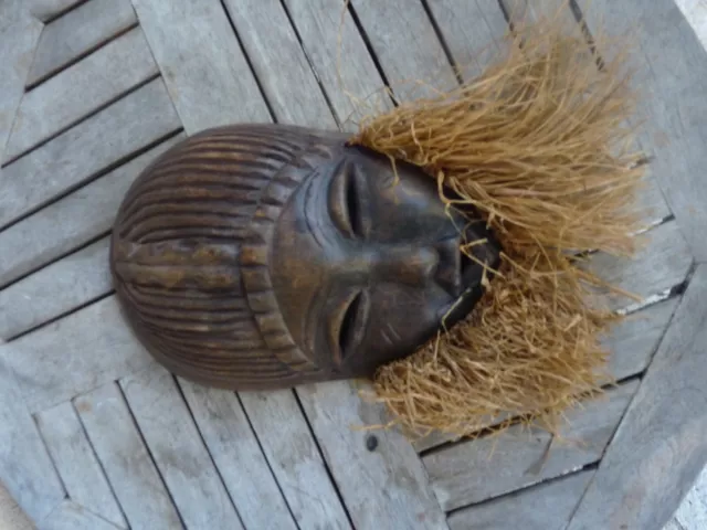 Masque africain bois sculpté collerette raffia