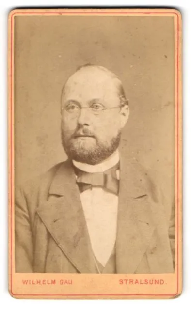 Fotografie Wilhelm Gau, Stralsund, Portrait stattlicher Herr mit Brille und Bar