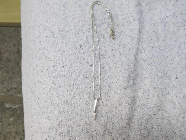 silver plated bar pendant with three crystals within .