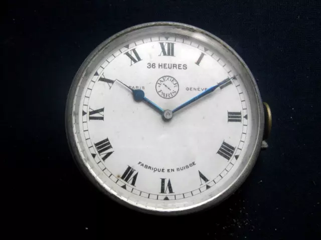 Montre Jaeger 36 heures, montage en façade, cadran blanc, remontoir latéral.