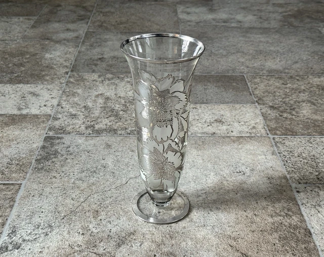 Coppia di vasetti in argento sbalzato decorati a volute e motivi