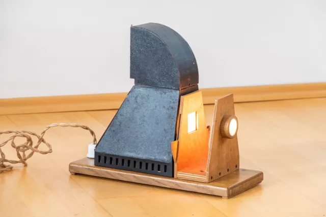 alter Projektor ohne Objektiv in Holzkiste, Lampe brennt!