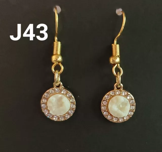 Small white earrings on gold colored hooks