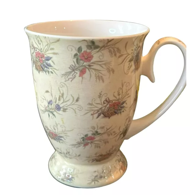 Pretty coffee or tea mug with pedestal base. Cream with baskets of pastel flower