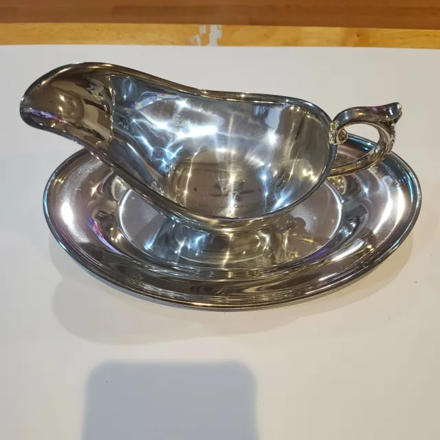 Vintage silver plated gravy boat with tray. Has ornate edging on tray and...