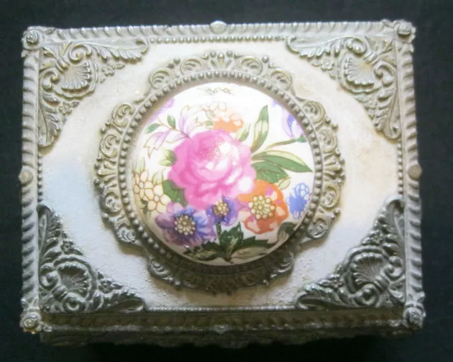 Embossed white metal trinket box .On 4  cabriole legs . Lid with ceramic plaque