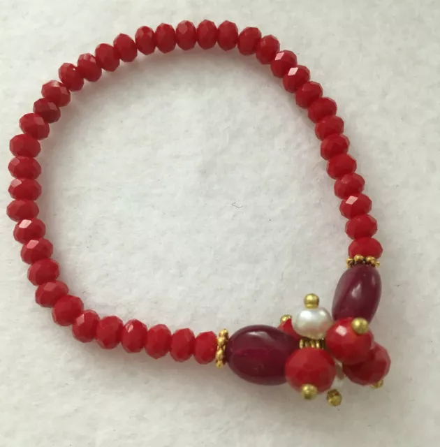 Neuf bracelet en perles de verre rouges et détails dorés