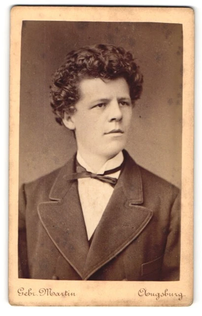 Fotografie Gebr. Martin, Augsburg, Portrait dunkelhaariger Herr mit Fliege im A