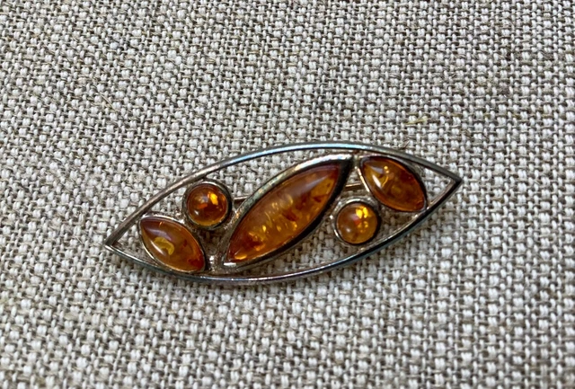Baltic amber and silver brooch. Early 1900s. Oval, multi stone piece.