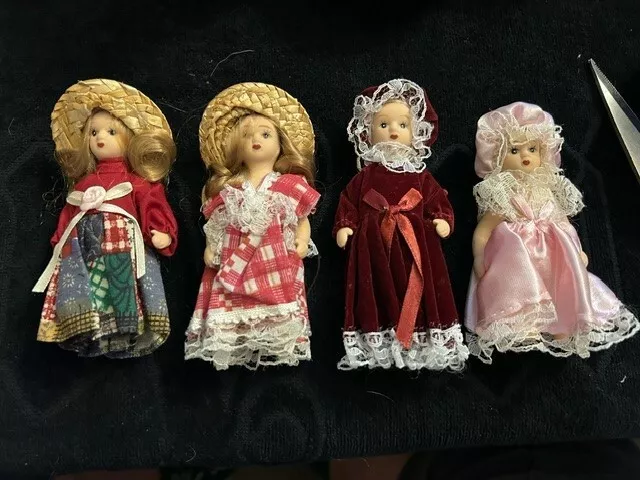 set of 4 porcelain dolls with outfit and hat new but old