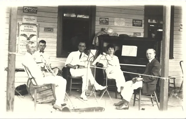 Old band on porch, Waukesta, Wisc.?; cigar/ginger ale ads on wall; 1910s RPPC