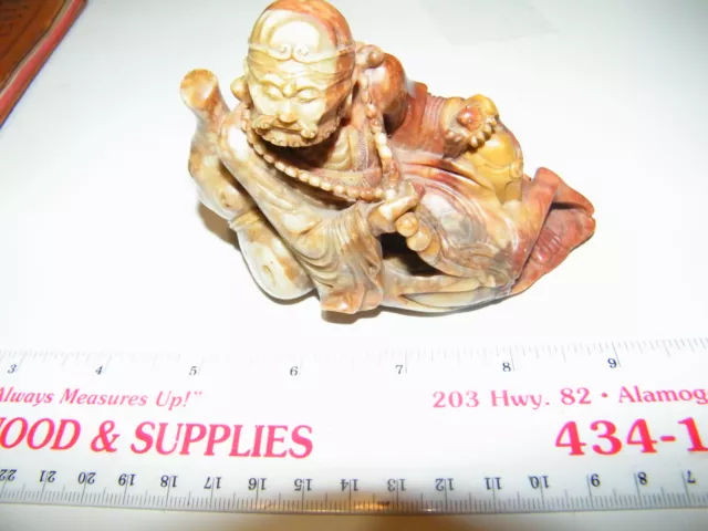 asian carved jade figure, bearded holding small creature in his hand, red green