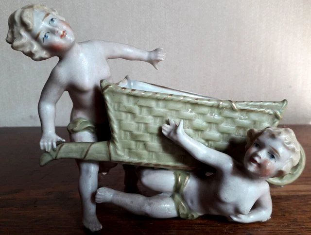 Ancien et beau biscuit polychrome. 2 jeunes filles à la brouette.