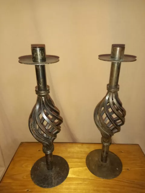 A pair of decorative heavy metal candlesticks
