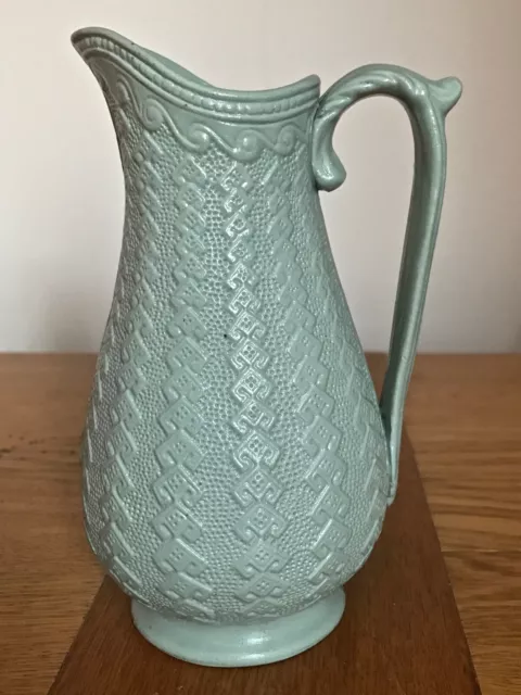 An Antique Relief moulded jug in green stoneware